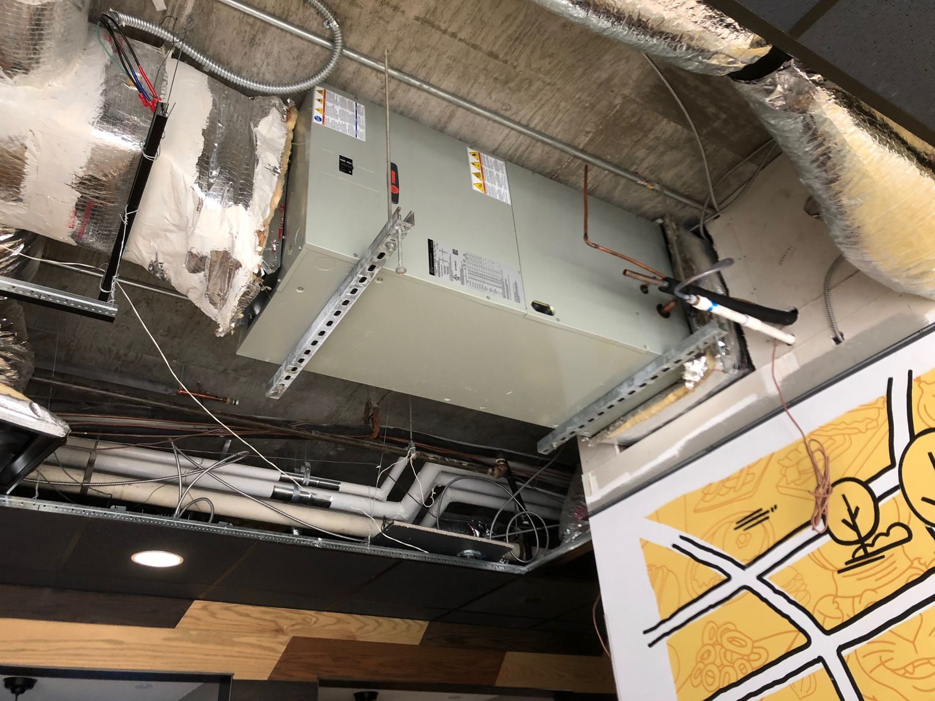 an air conditioner is hanging from the ceiling of a building next to a map