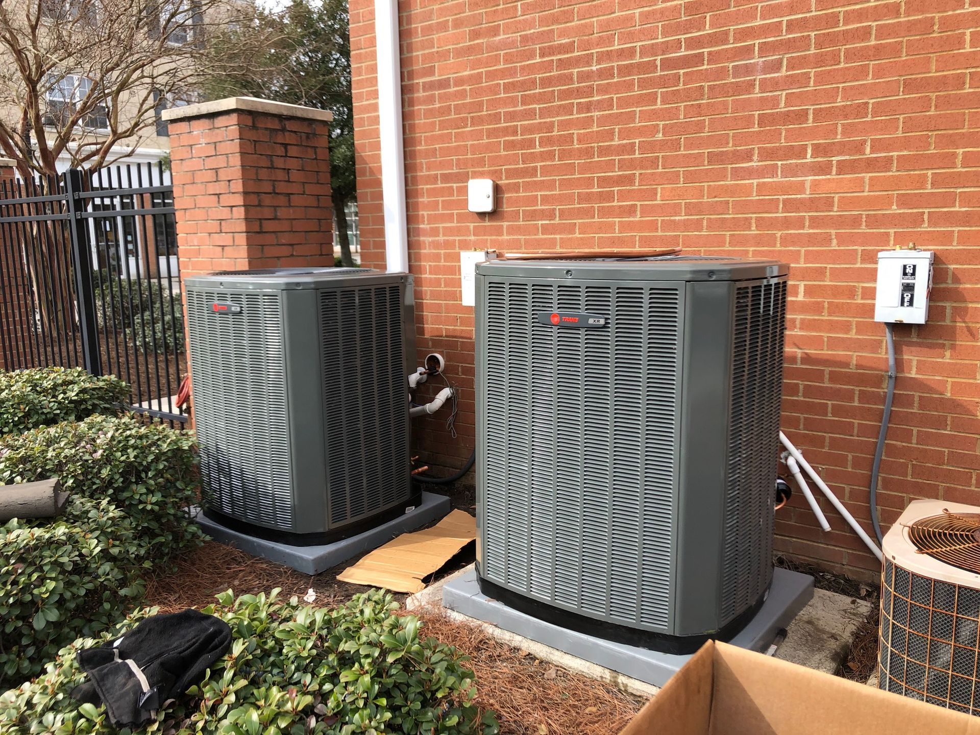 two air conditioners are sitting on the side of a brick building
