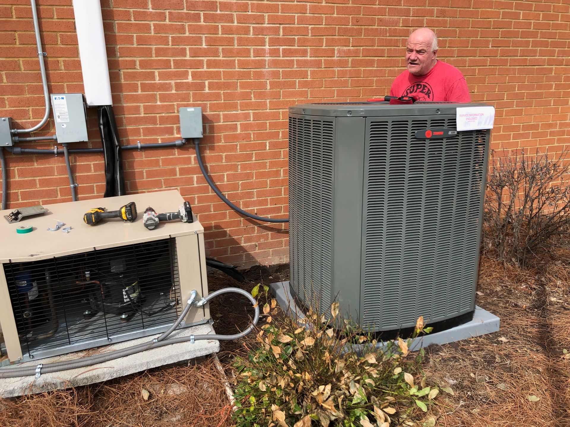a man is working on an air conditioner outside of a brick building