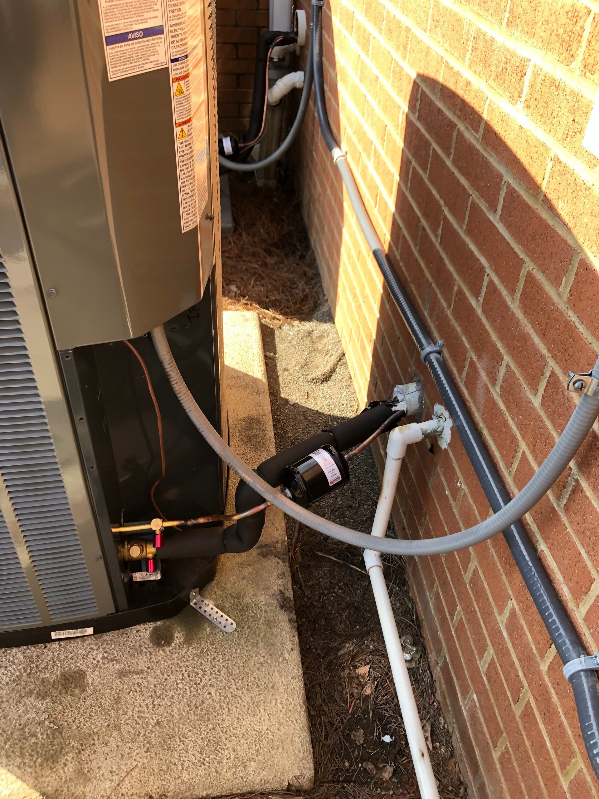 an air conditioner is being installed on the side of a brick building