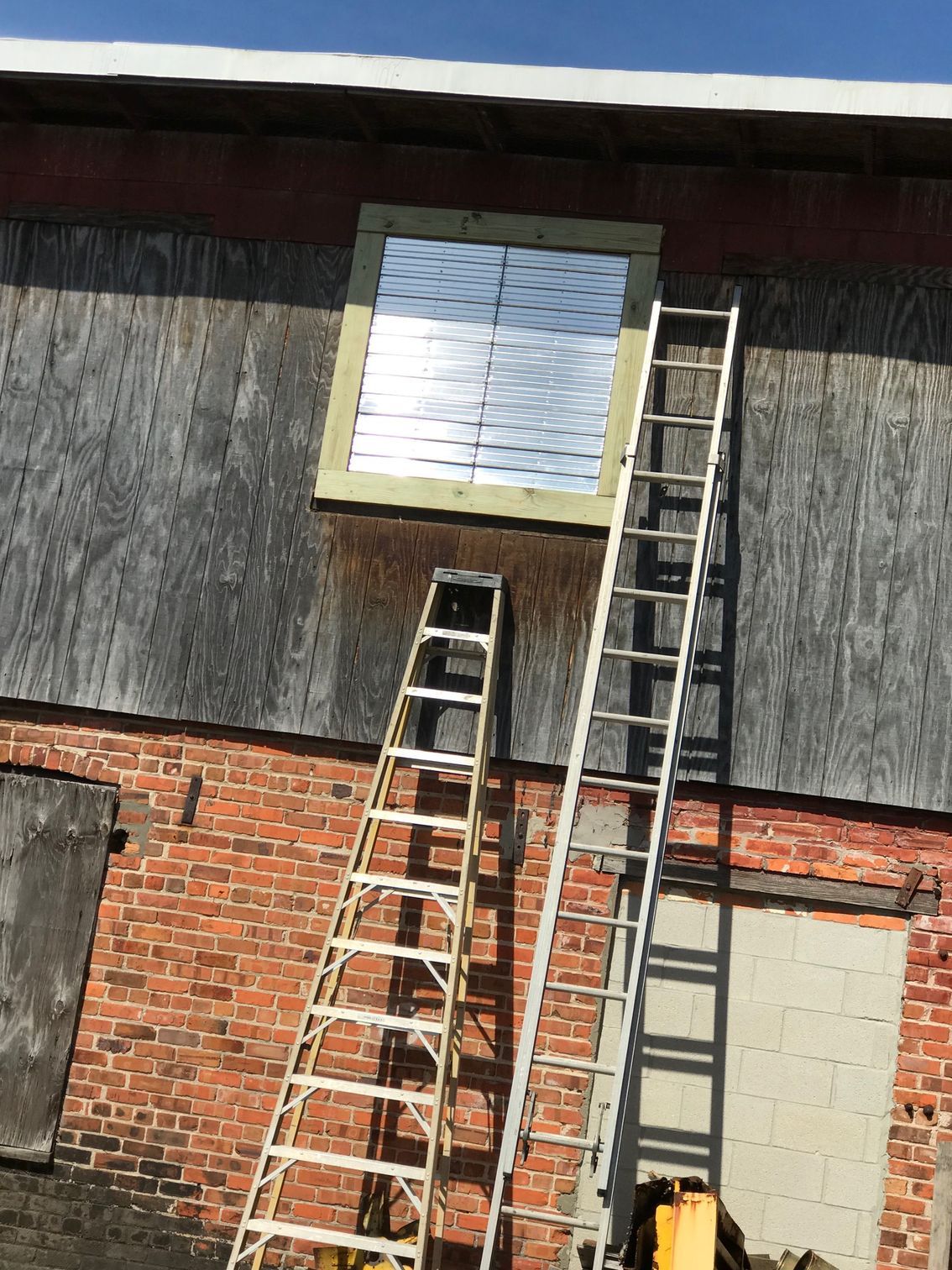 a ladder is sitting on top of a brick building 