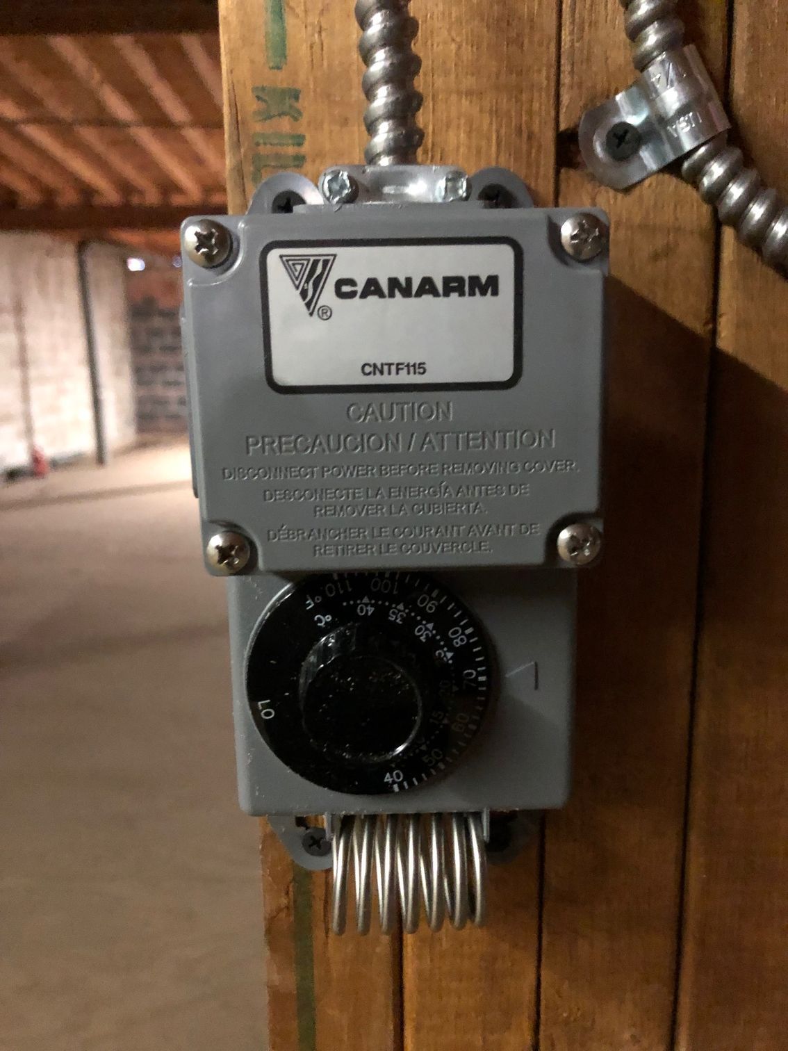 a canarm thermostat is mounted on a wooden wall
