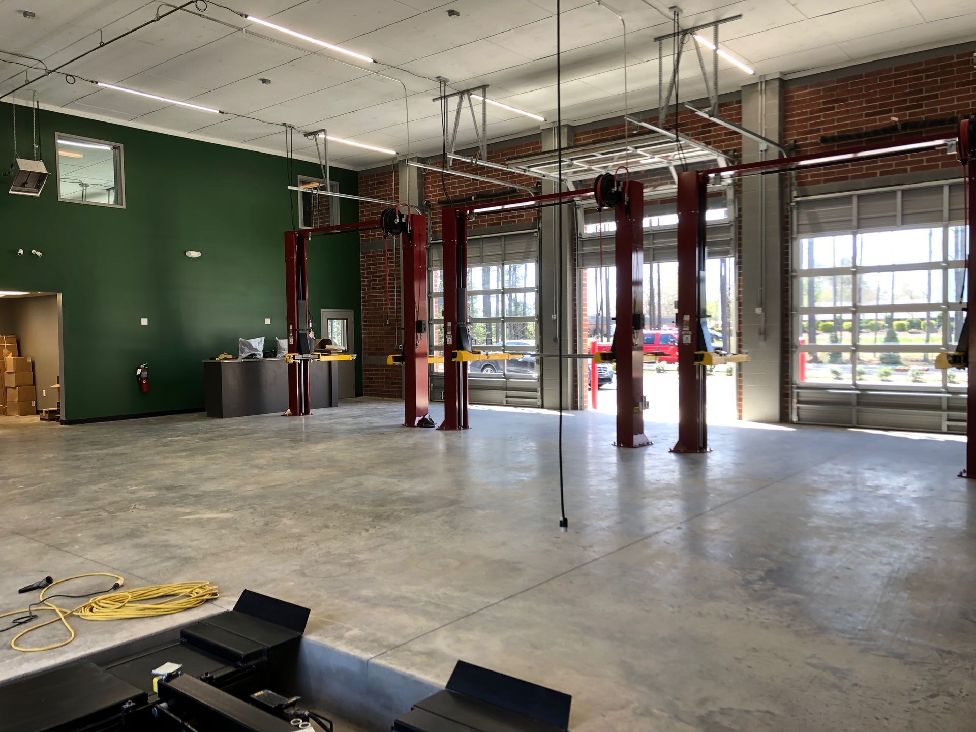 a large empty garage with a lot of lifts and a green wall