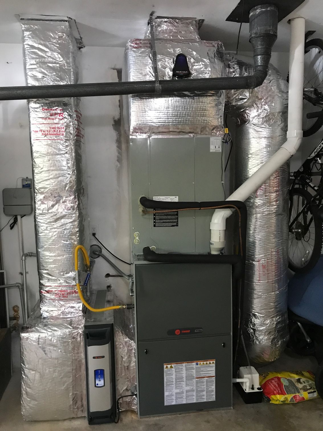 an air conditioner is sitting in a garage next to a bicycle 