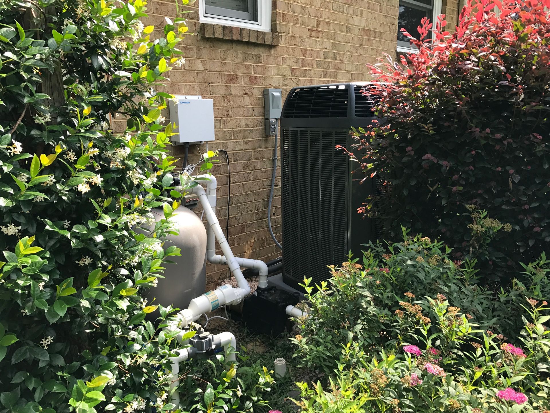 a large air conditioner is sitting in the backyard of a house 