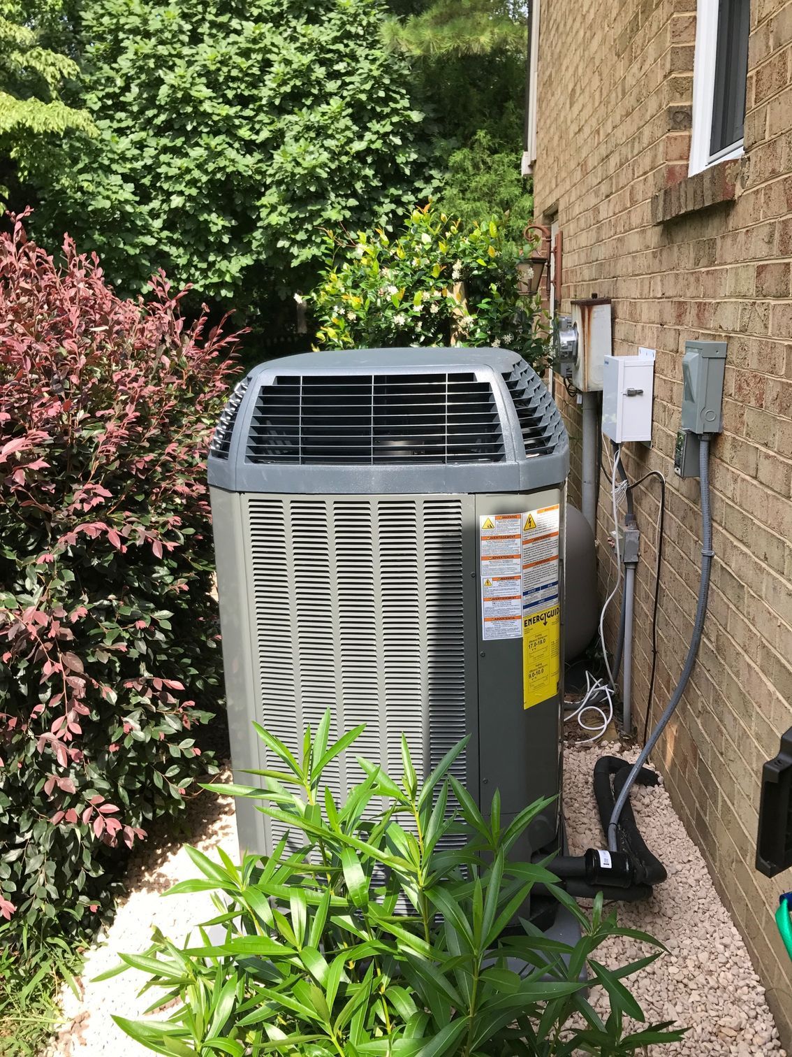 an air conditioner is sitting on the side of a brick house 