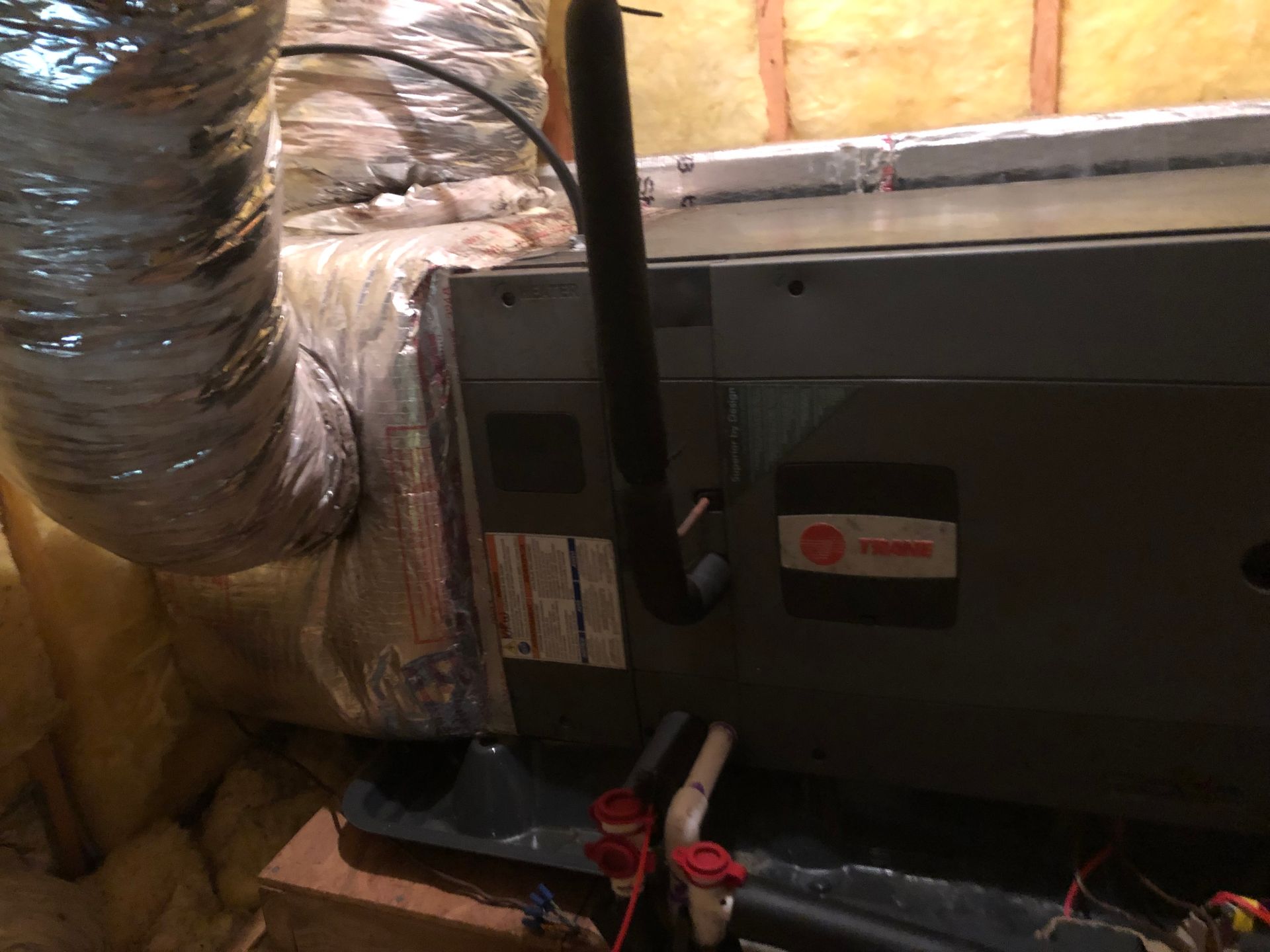 a furnace is sitting in a basement next to a duct