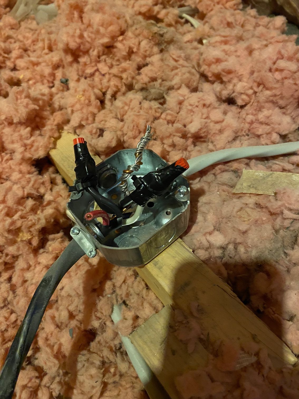 a box with wires coming out of it is in an attic