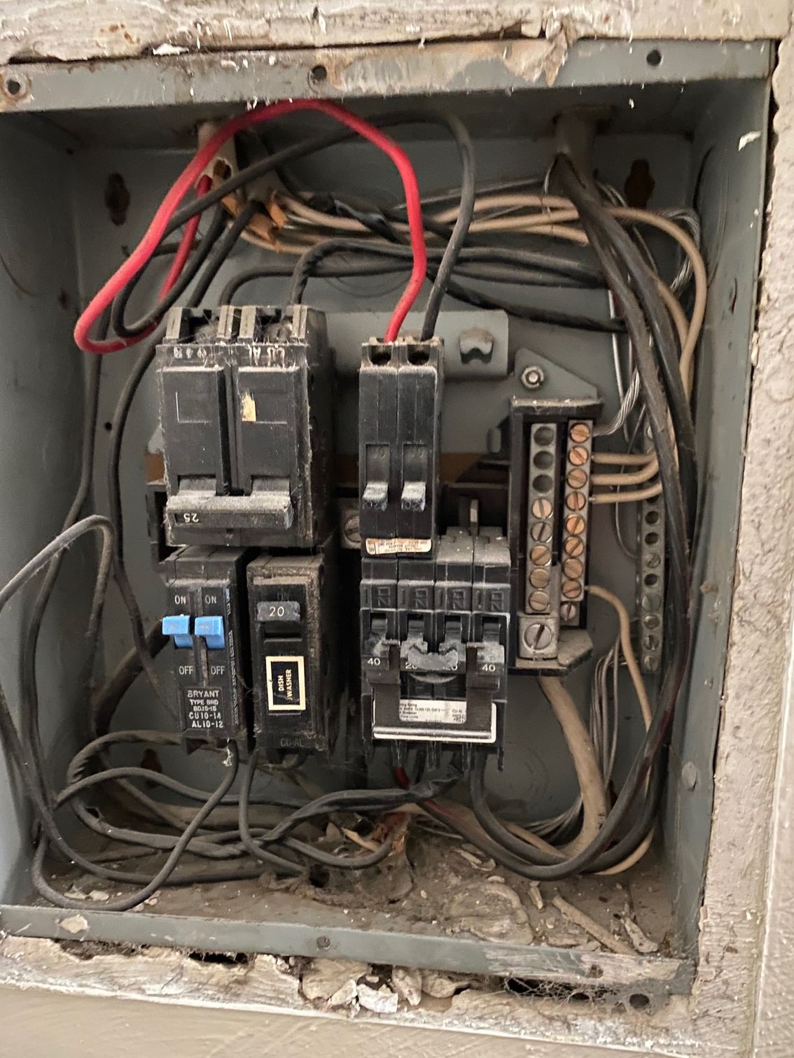a dirty electrical box with a bunch of wires coming out of it