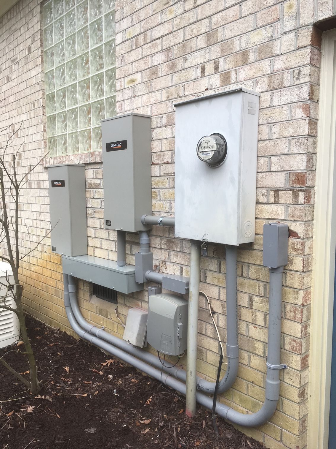 there are a lot of electrical boxes on the side of a brick building 