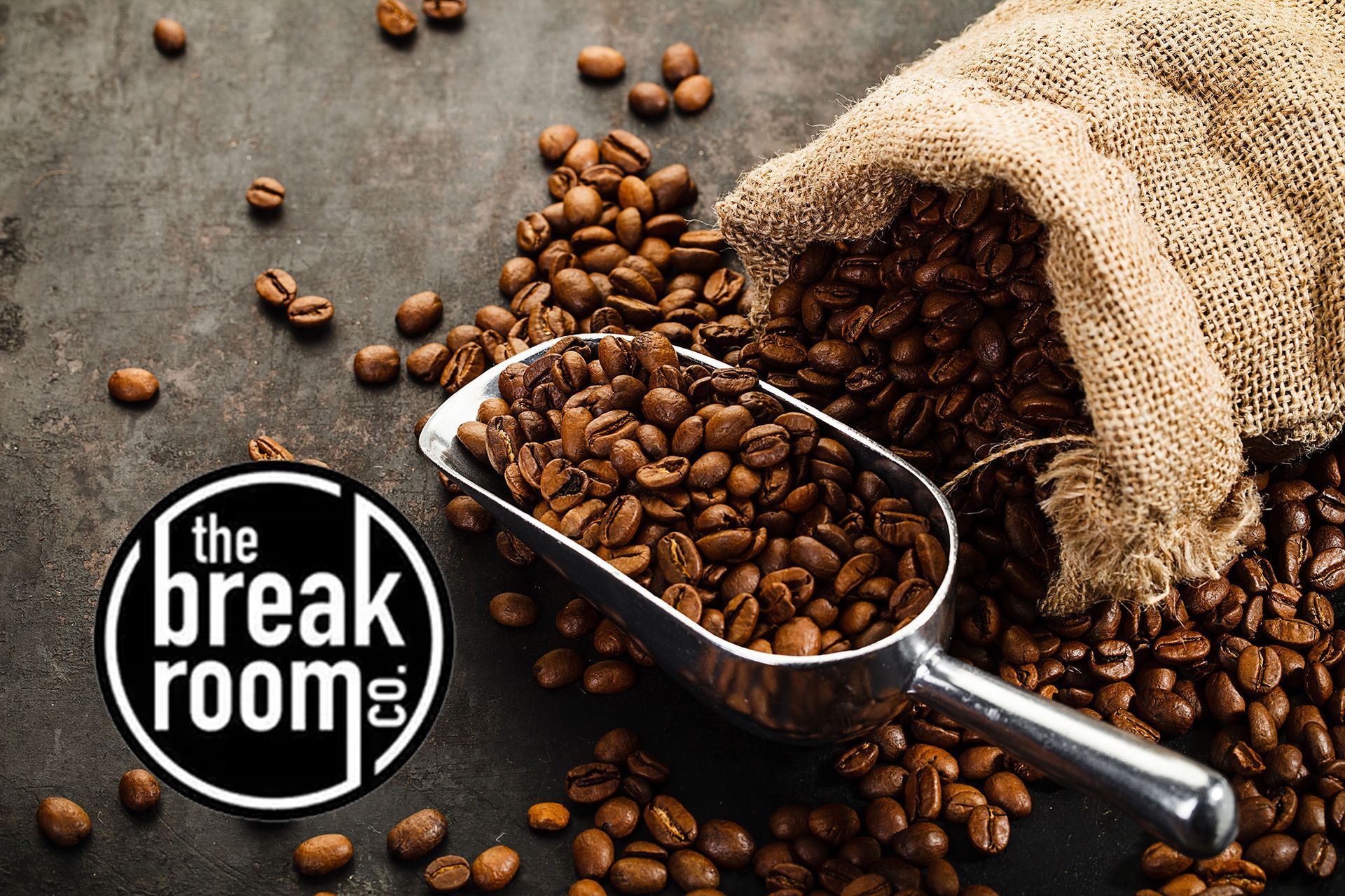 A bag of coffee beans and a scoop of coffee beans on a table.