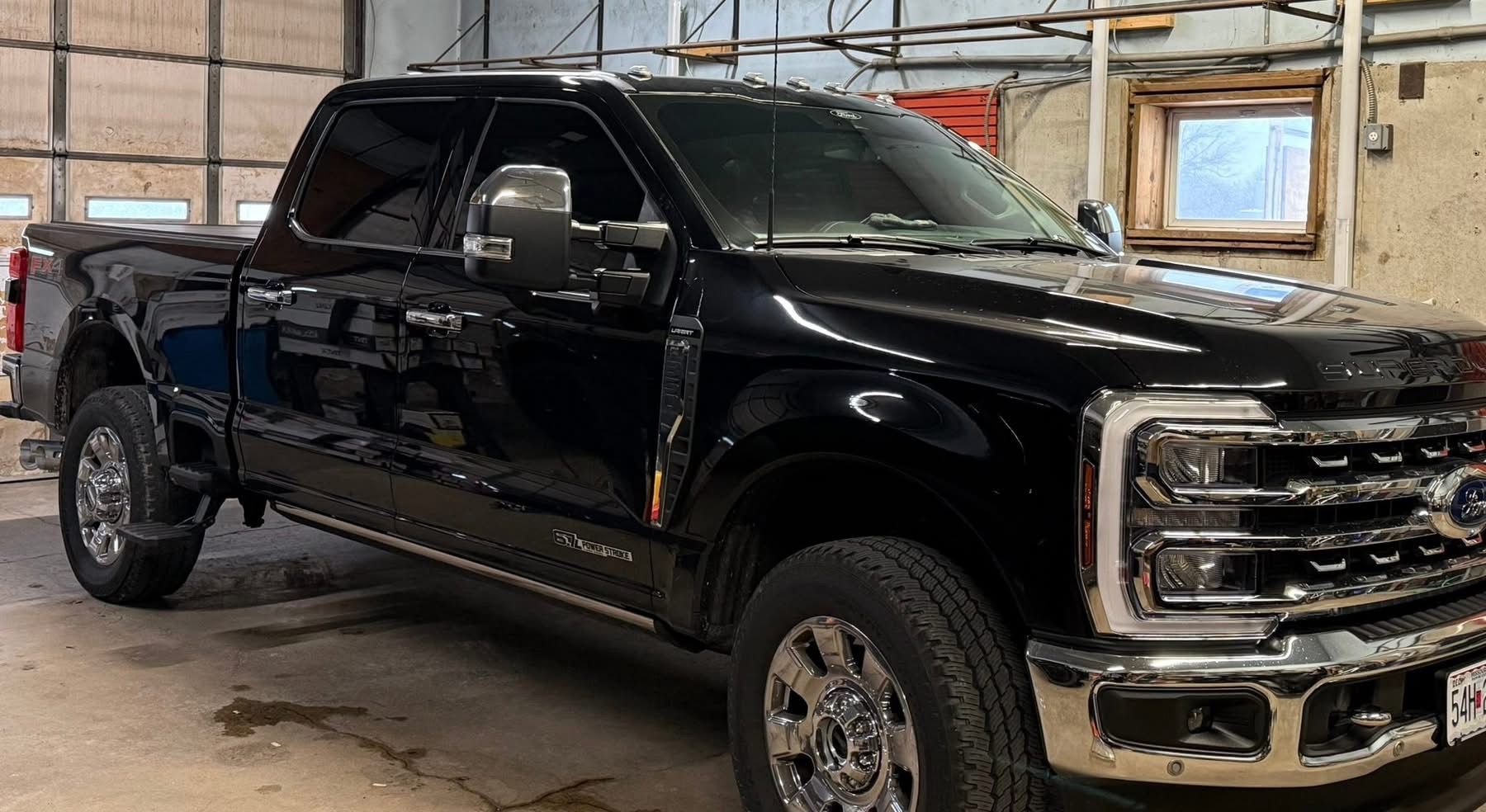Black pickup truck parked inside a garage or workshop.