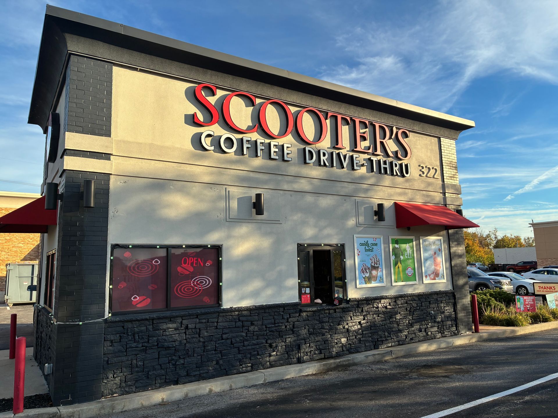 Scooters Coffee Drive-Thru storefront with beige walls, black trim, and red signage under a blue sky