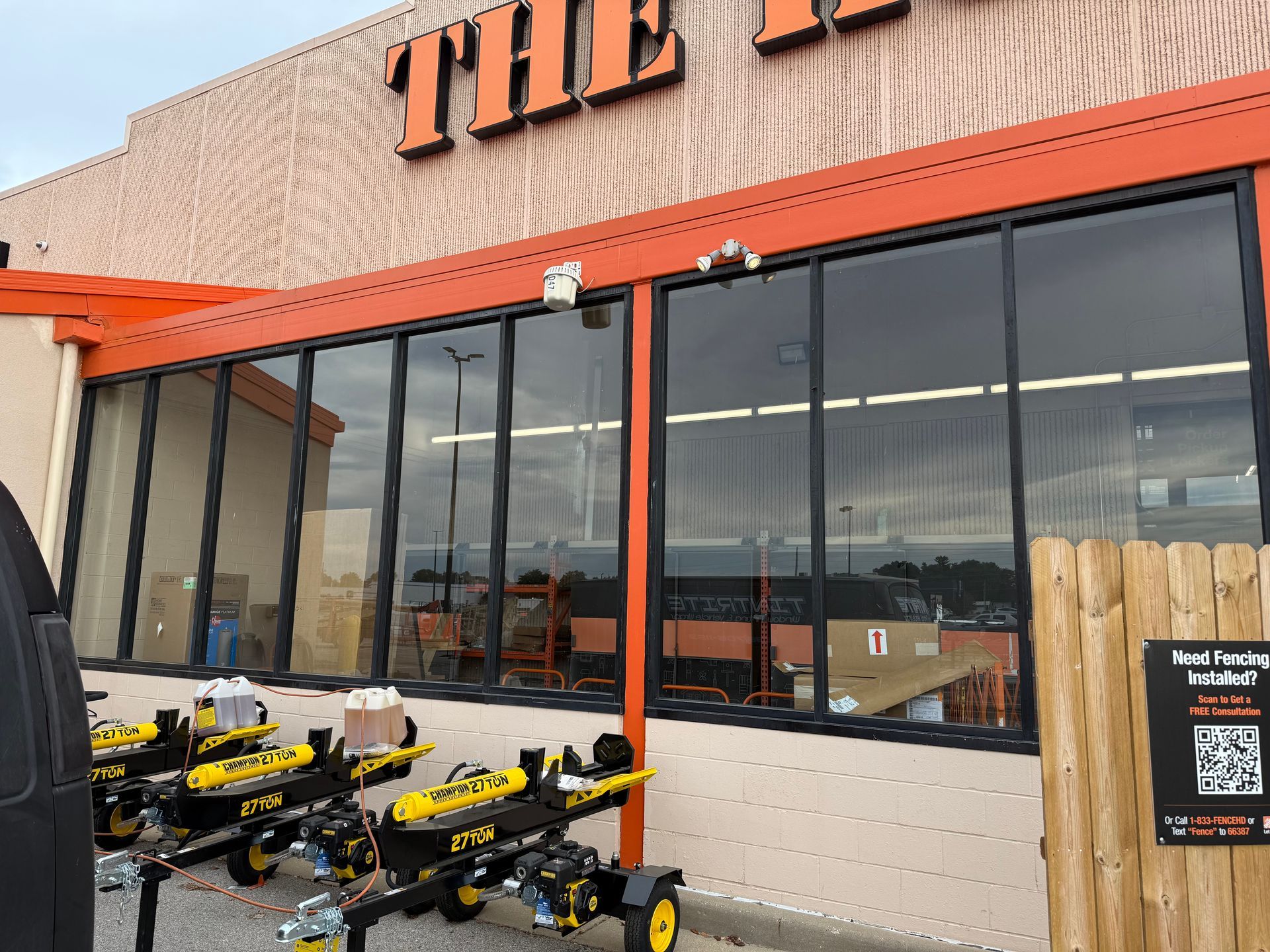 Storefront with large windows, orange trim, and several yellow strollers parked outside