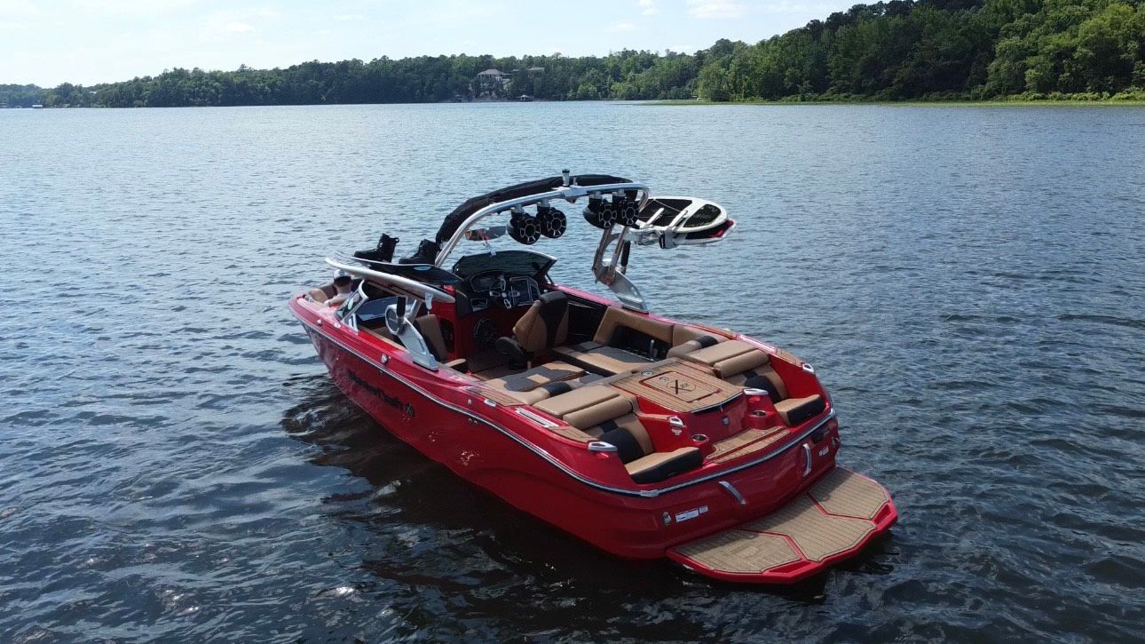 A red boat is floating on top of a lake.