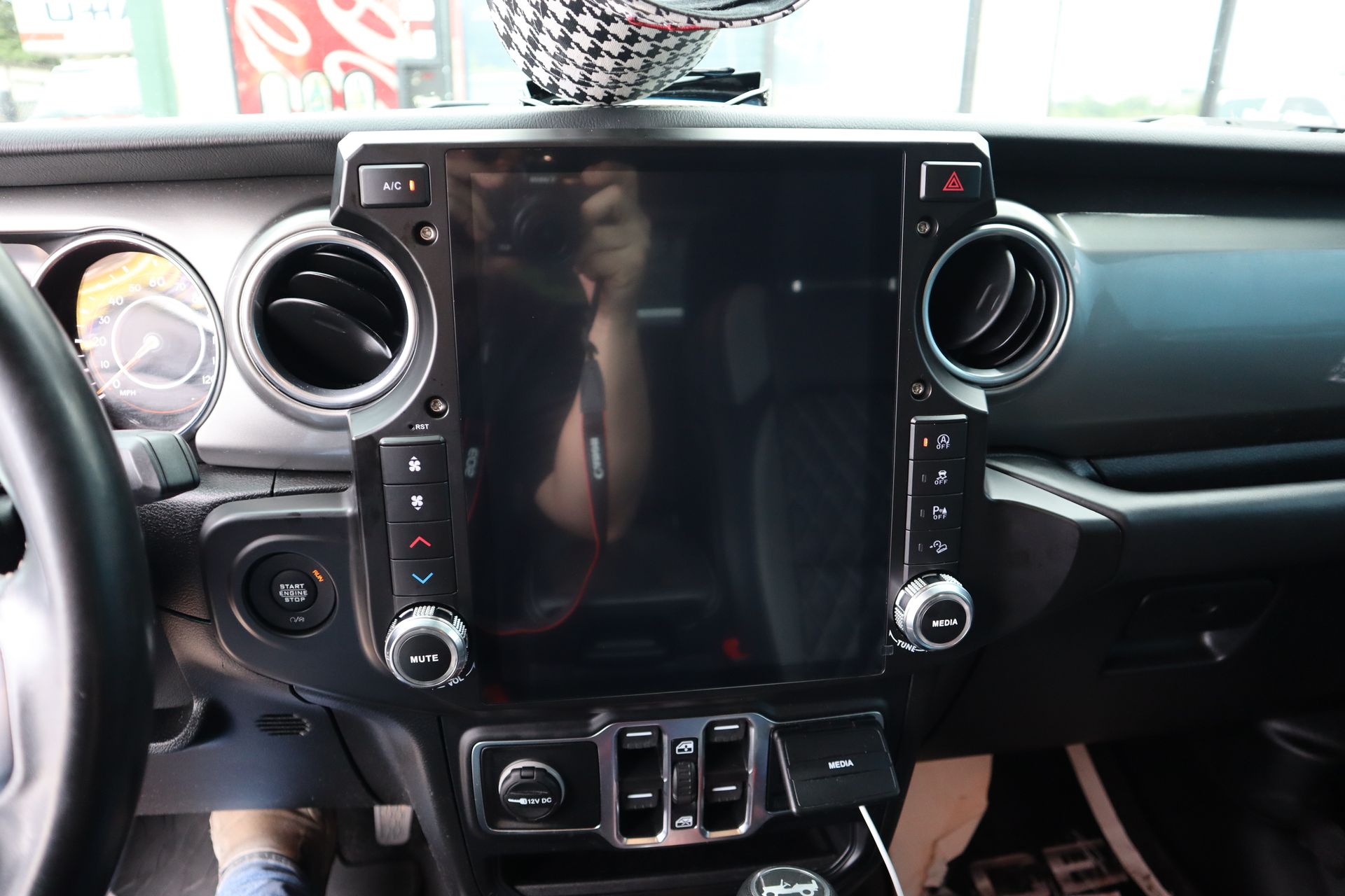A person is taking a picture of the dashboard of a car.