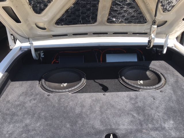The trunk of a car with two speakers in it