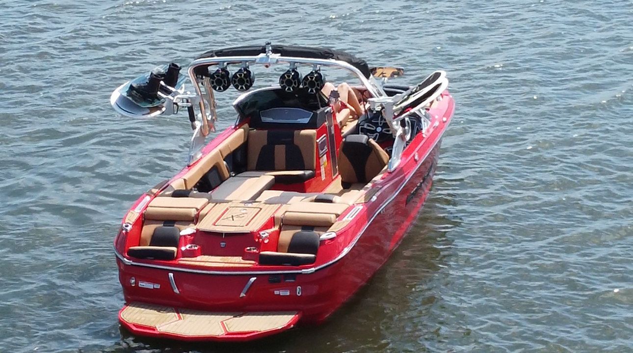 A red boat is floating on top of a body of water.