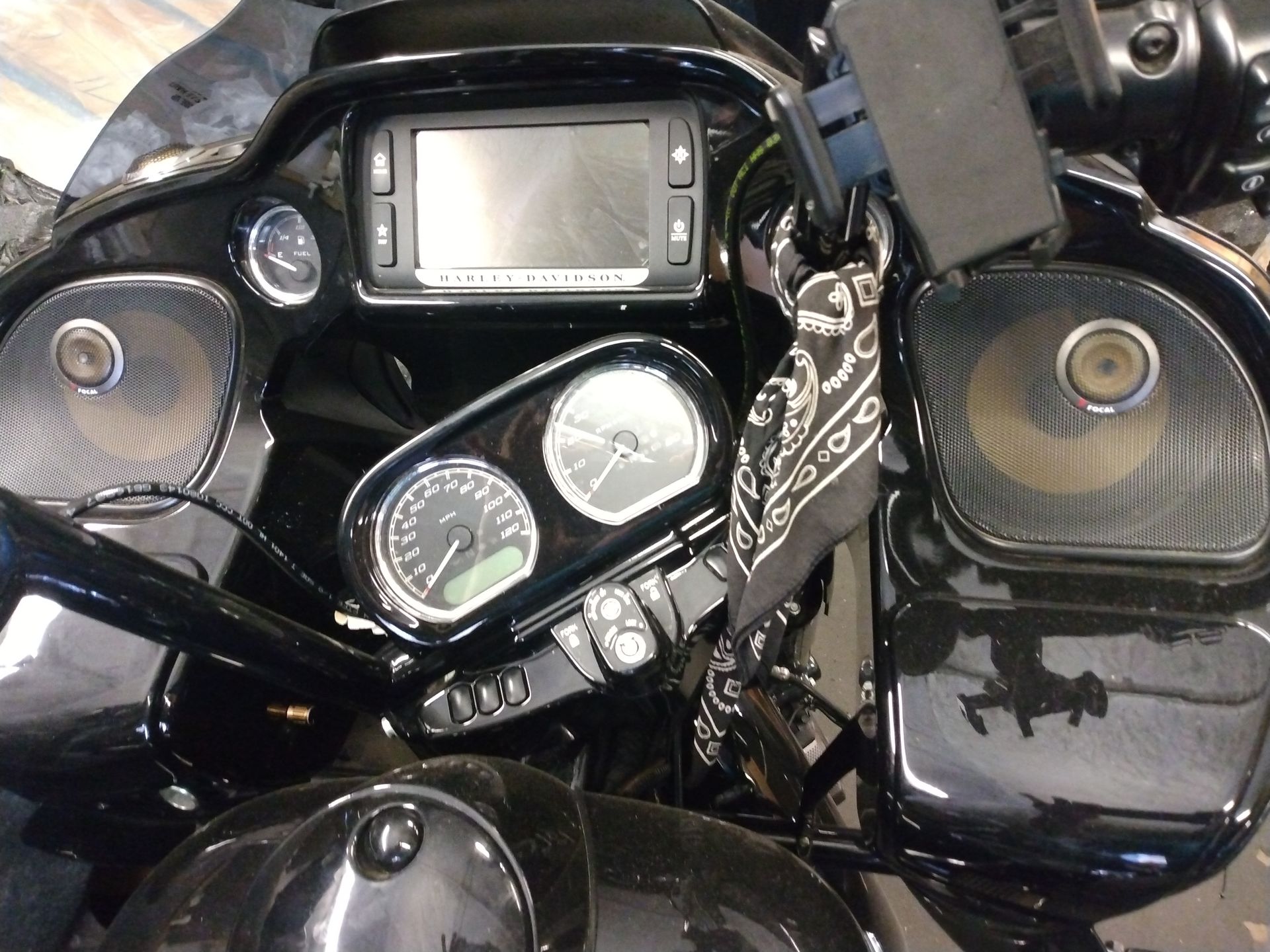 A black harley davidson motorcycle with a bandana on the handlebars