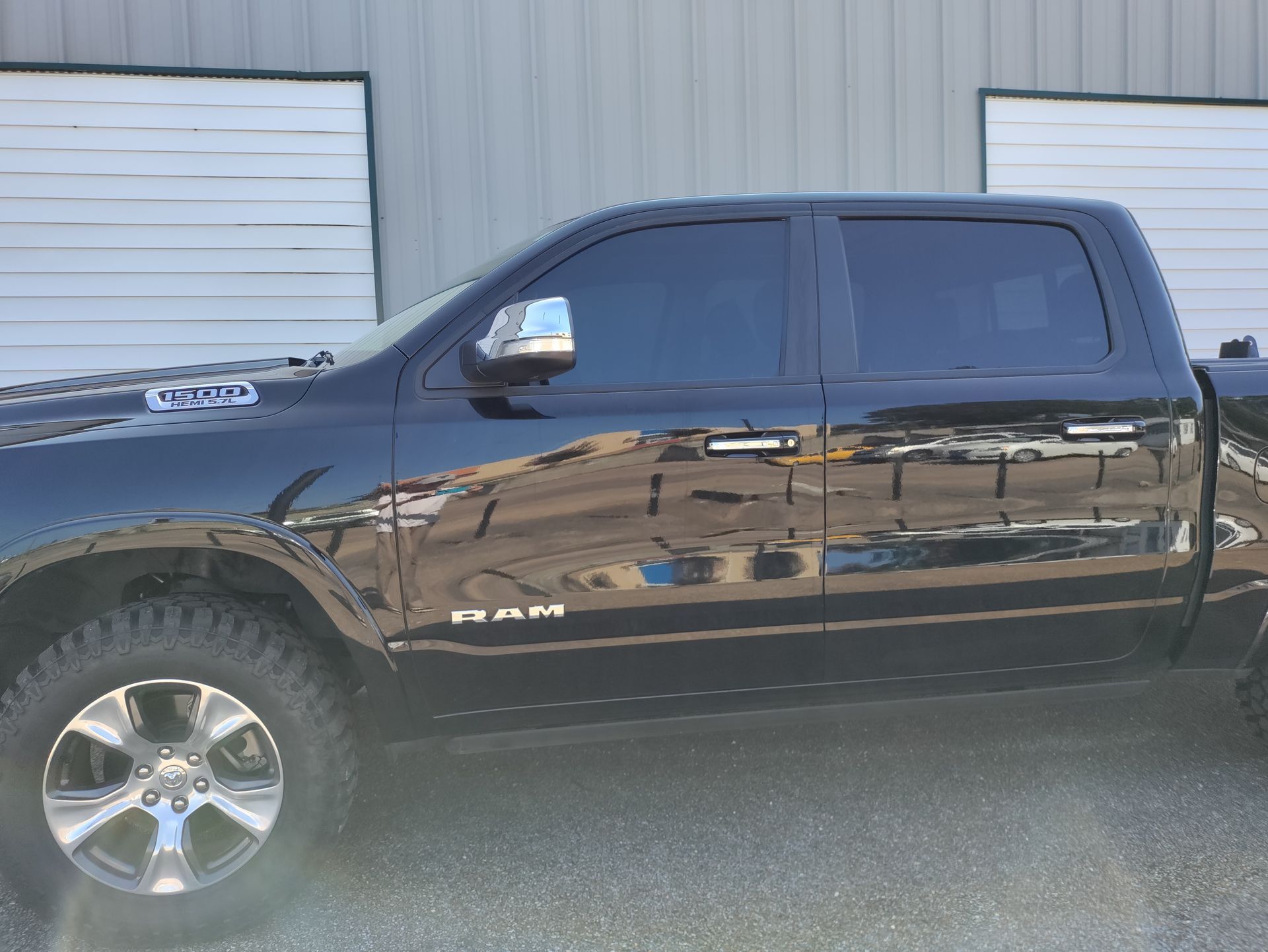 A black truck is parked in front of a building.