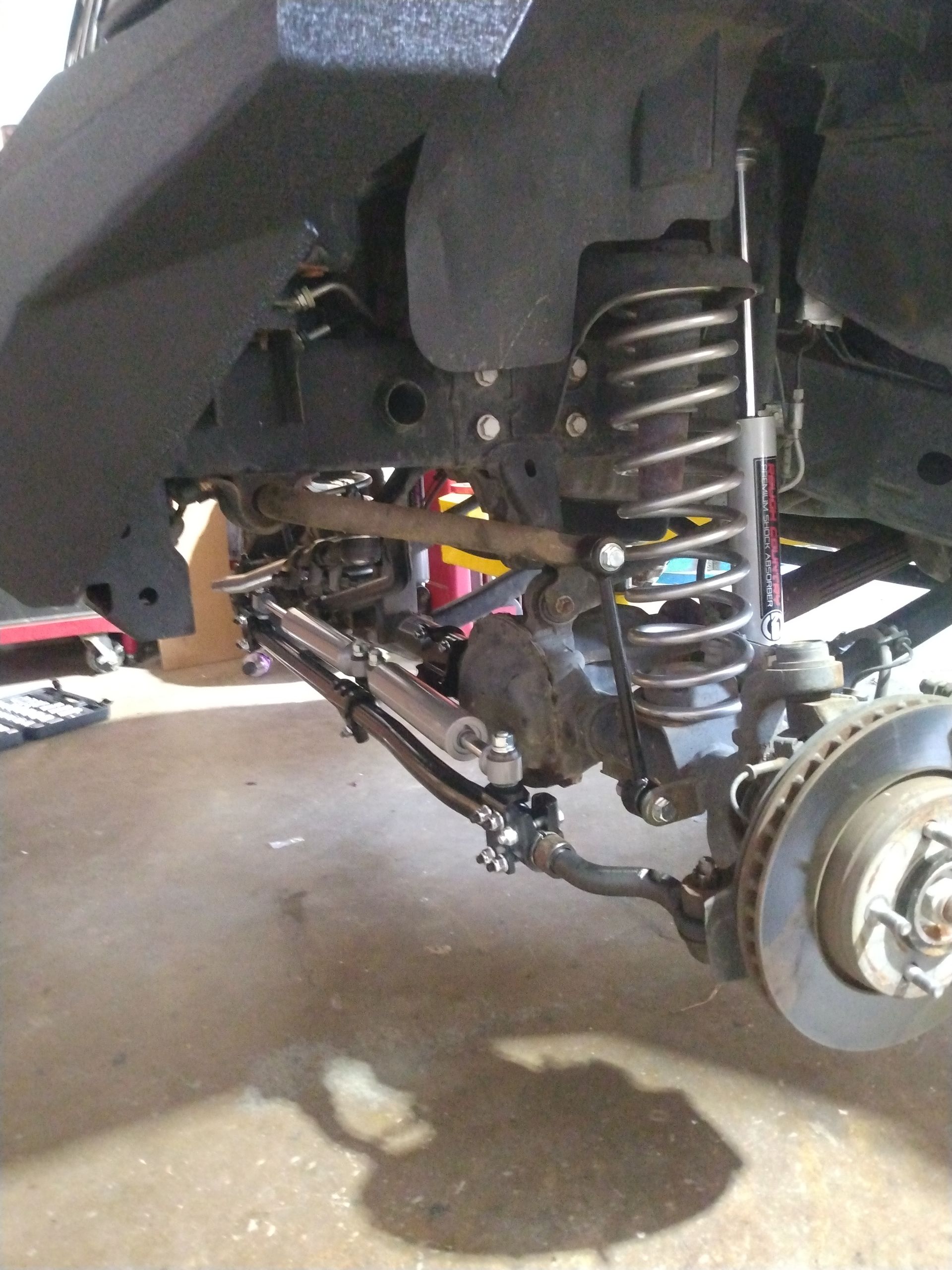 A close up of the underside of a jeep with a shock on it.