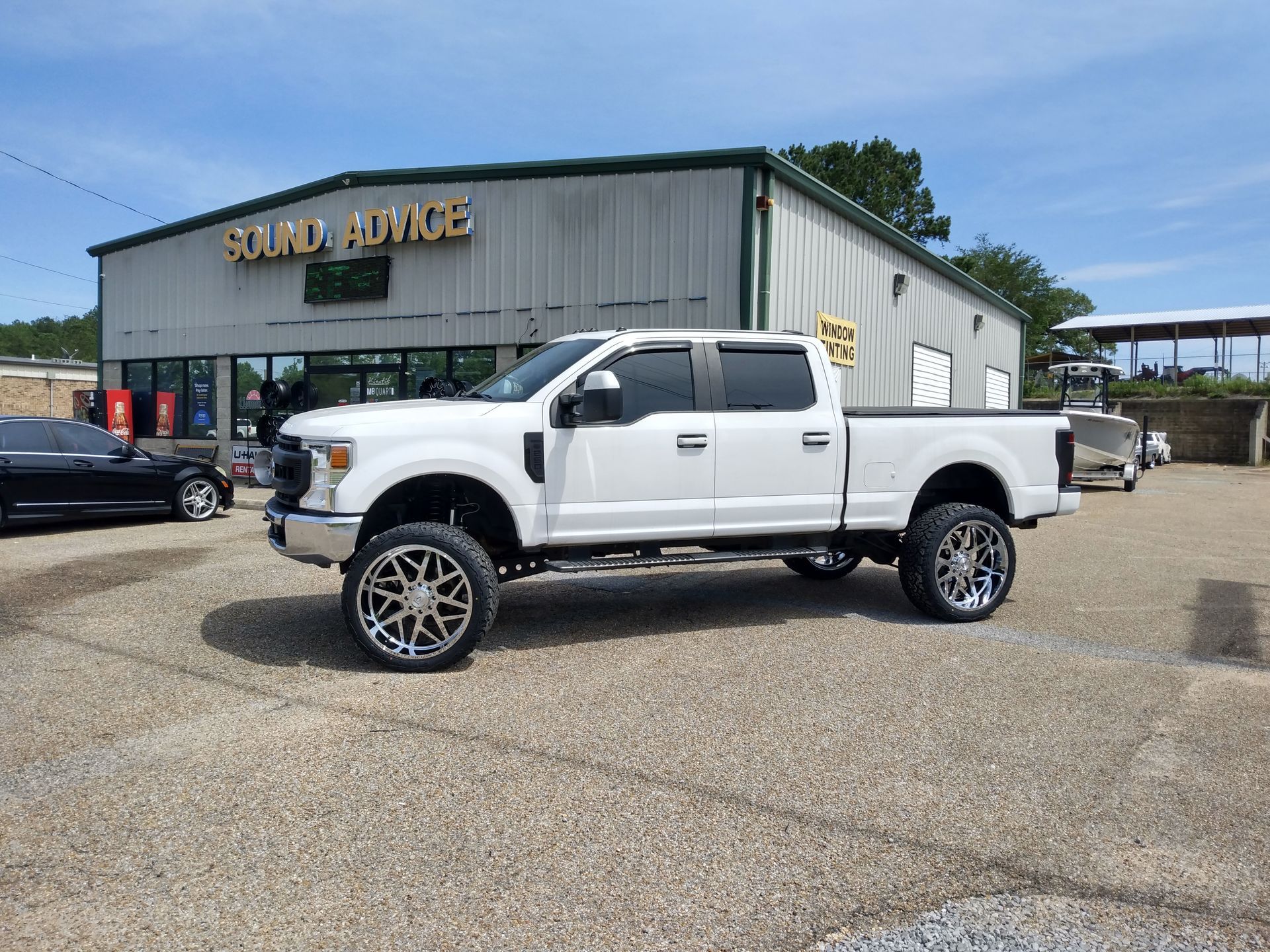 A white pickup truck is parked in front of a building.