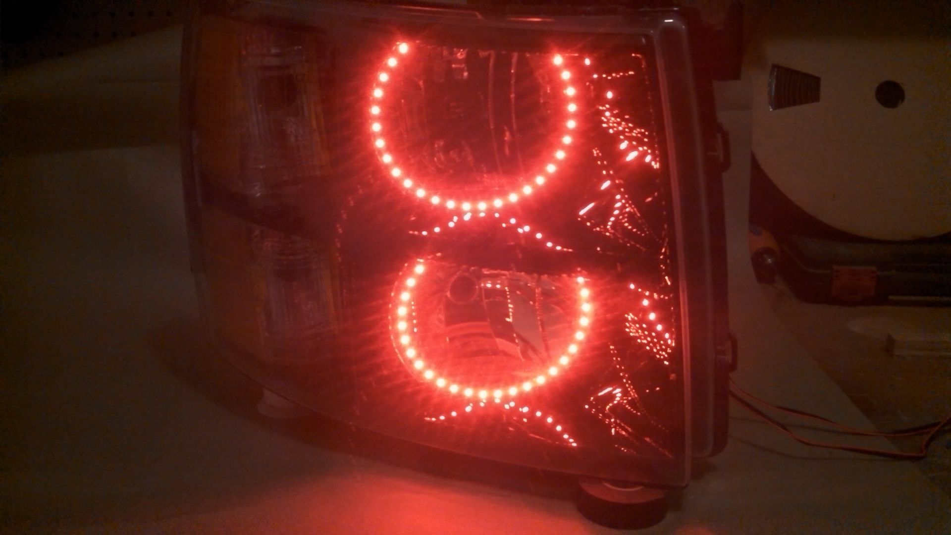 A close up of a headlight with red lights on it