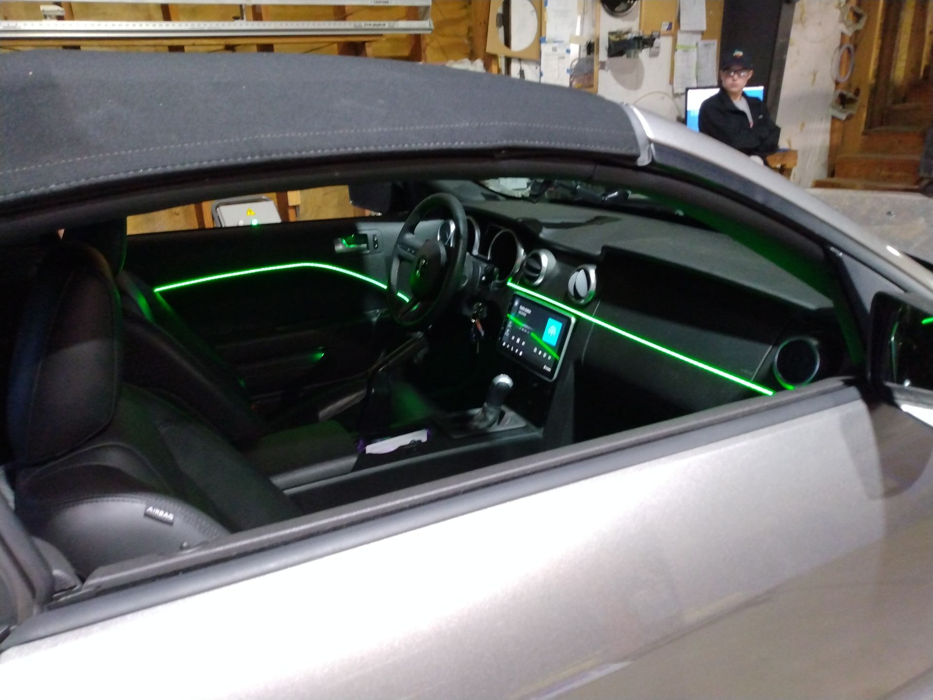 The inside of a car with green lights on the dashboard