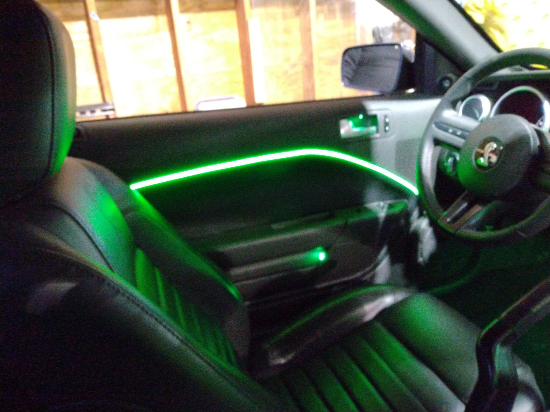 A car with green lights on the door and steering wheel