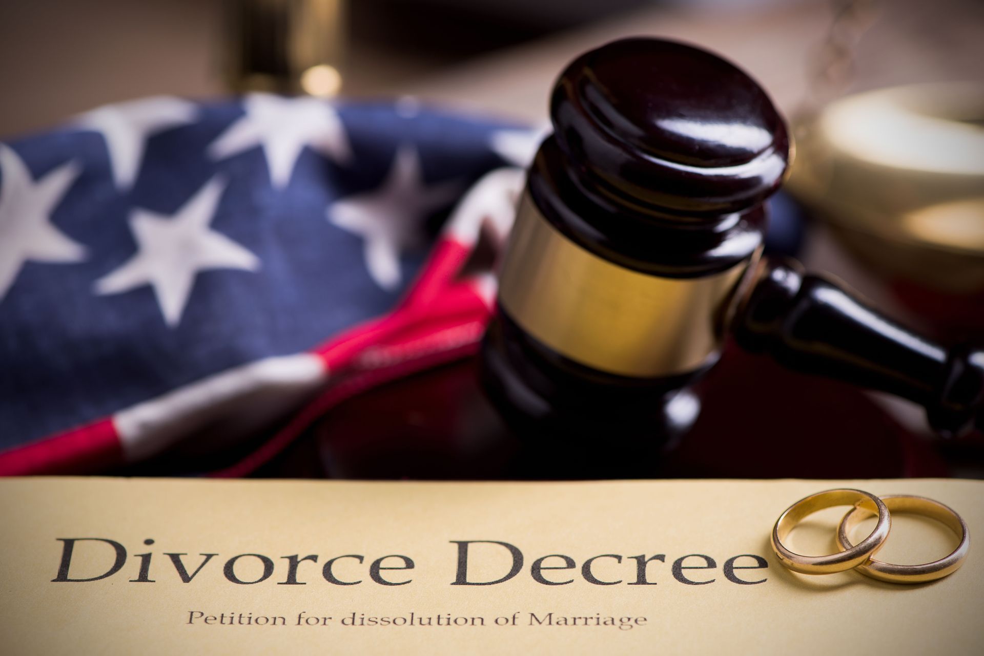 A gavel is sitting next to a divorce decree and an American flag.