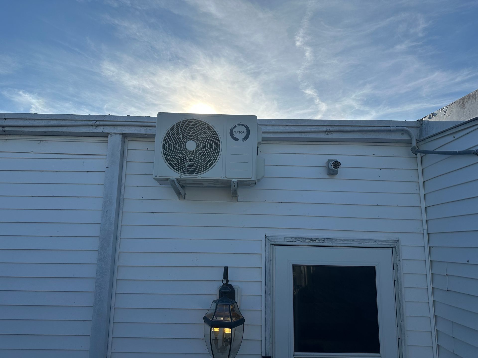 A white house with a large air conditioner on the side of it.