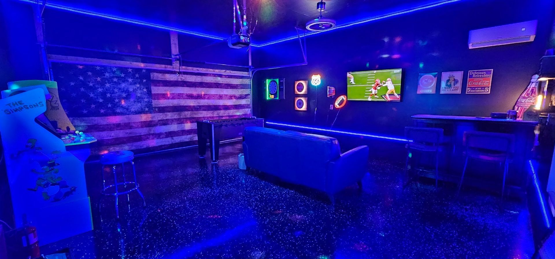 A man is standing in a dark room with blue lights.