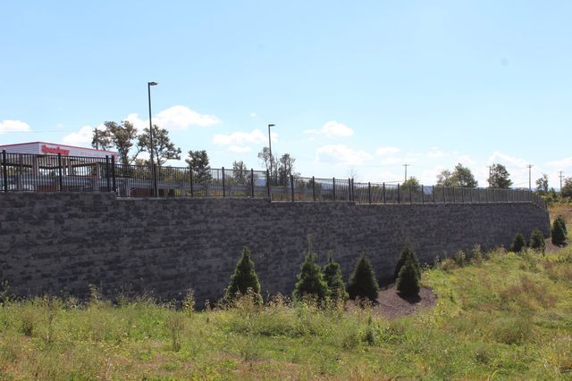 A large stone wall surrounds a grassy field.