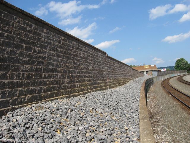 A brick wall along the side of a train track