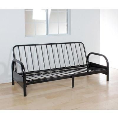 A black futon frame is sitting on a wooden floor in front of a window.