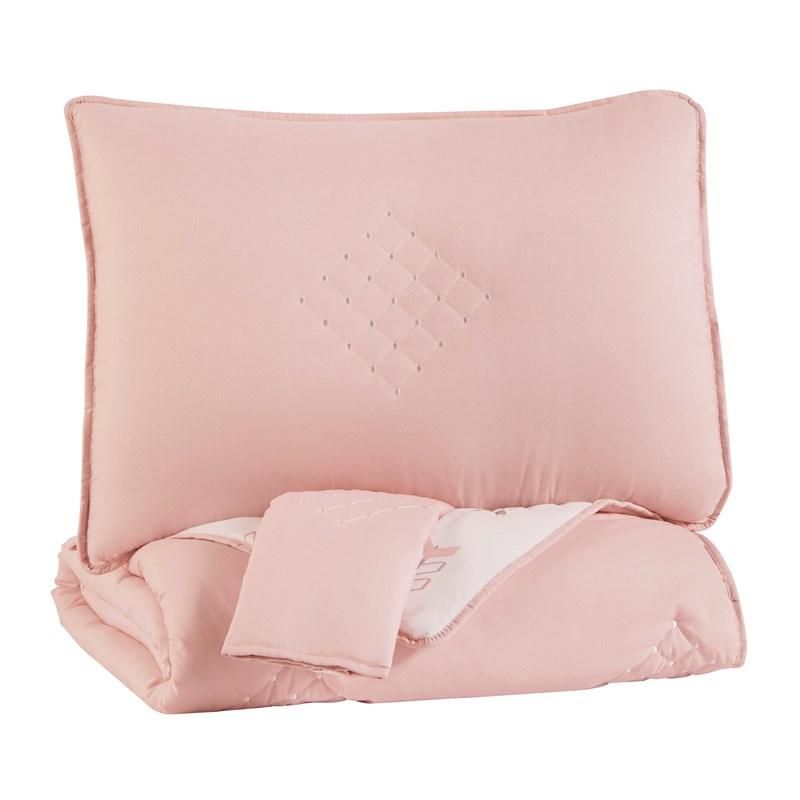 A pink comforter and pillow on a white background.