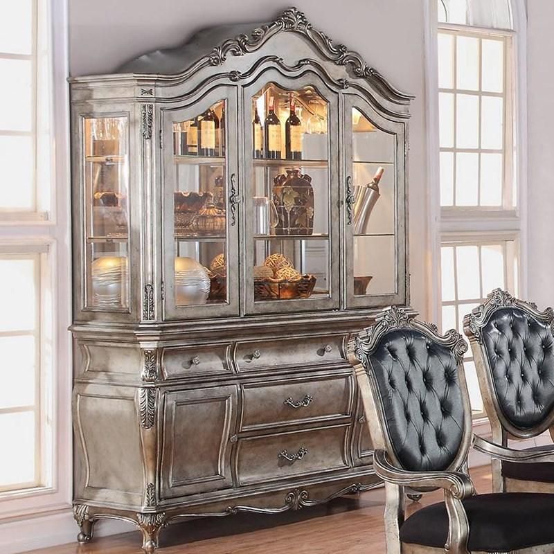 A silver hutch with black chairs in front of it