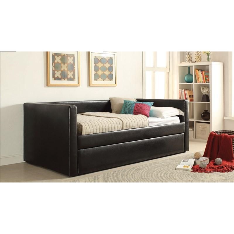 A black day bed is sitting in a living room next to a bookshelf.