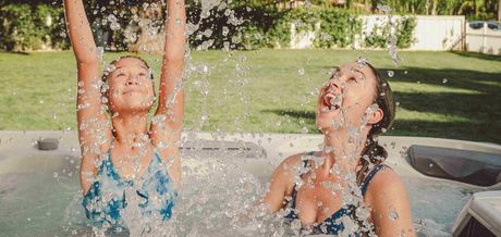 A woman and a child are playing in a hot tub.