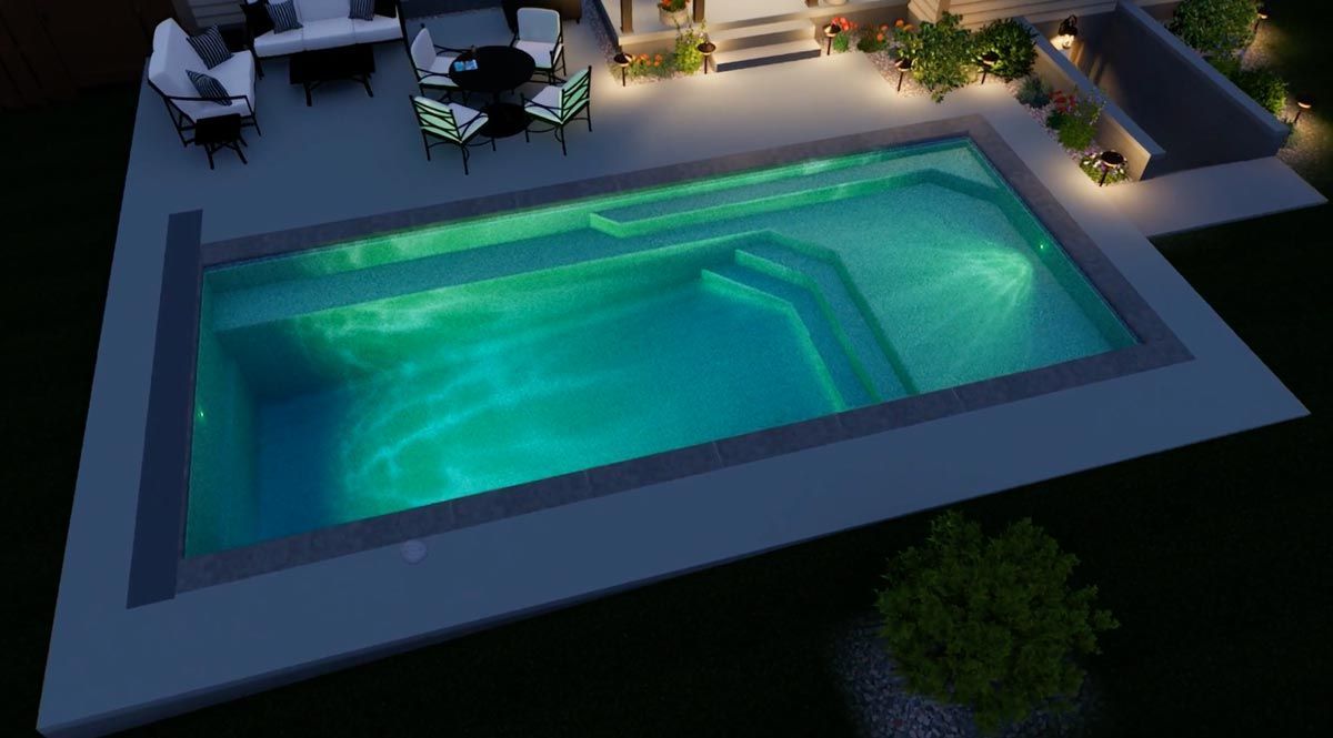 Nighttime view of a turquoise pool with stairs, surrounded by concrete patio and outdoor furniture.
