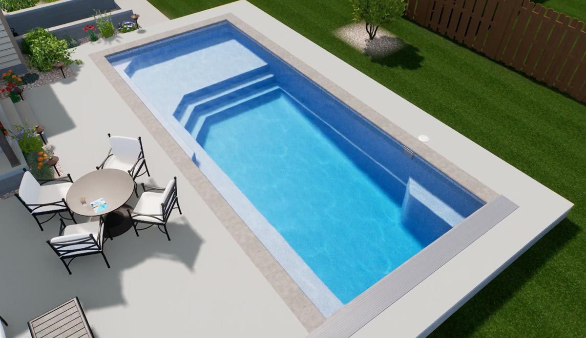 Aerial view of a rectangular swimming pool with steps, patio furniture, and green grass.
