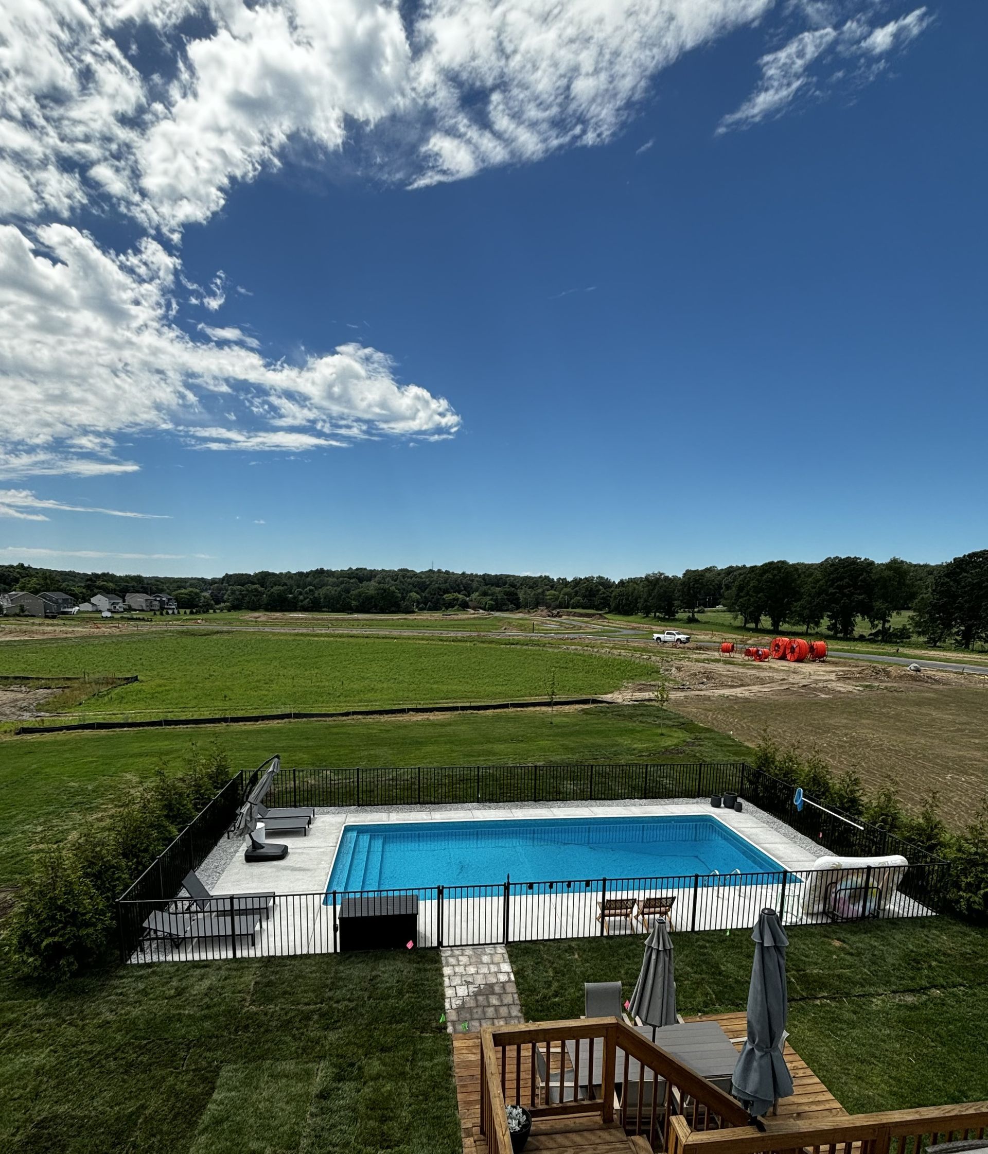 A large swimming pool in the middle of a grassy field
