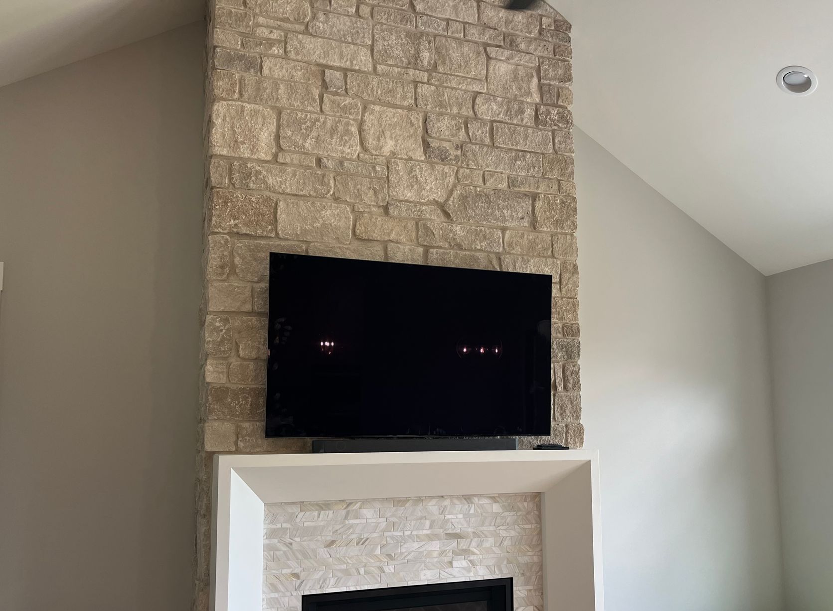 A living room with a fireplace and a flat screen tv mounted on the wall above it.