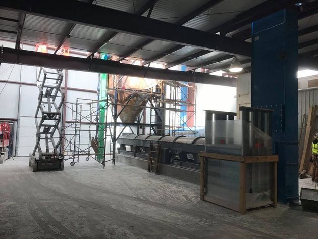 Interior construction site with steel beams, scaffolding, and drywall in progress