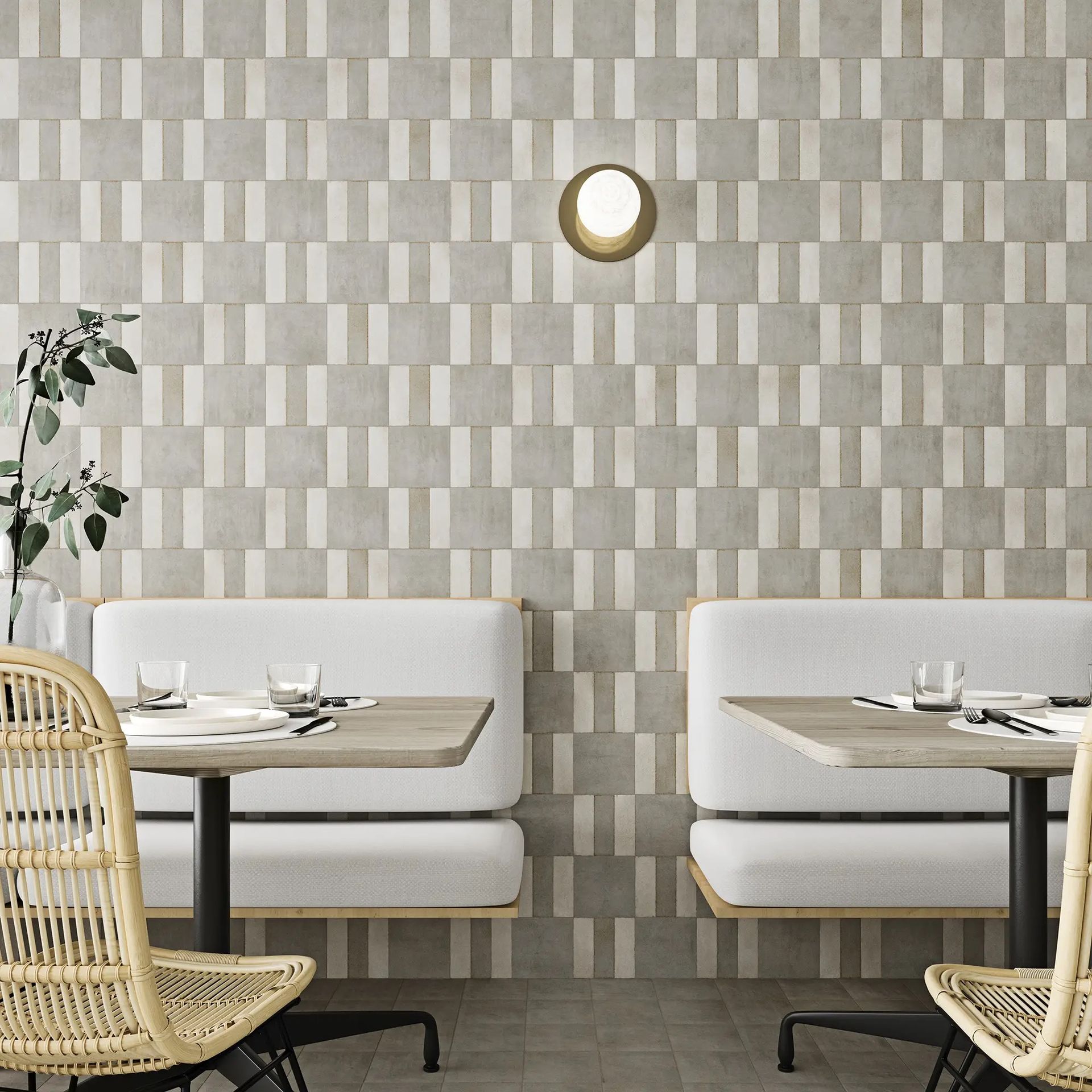 A restaurant with tables and chairs in front of a wall with a geometric pattern.