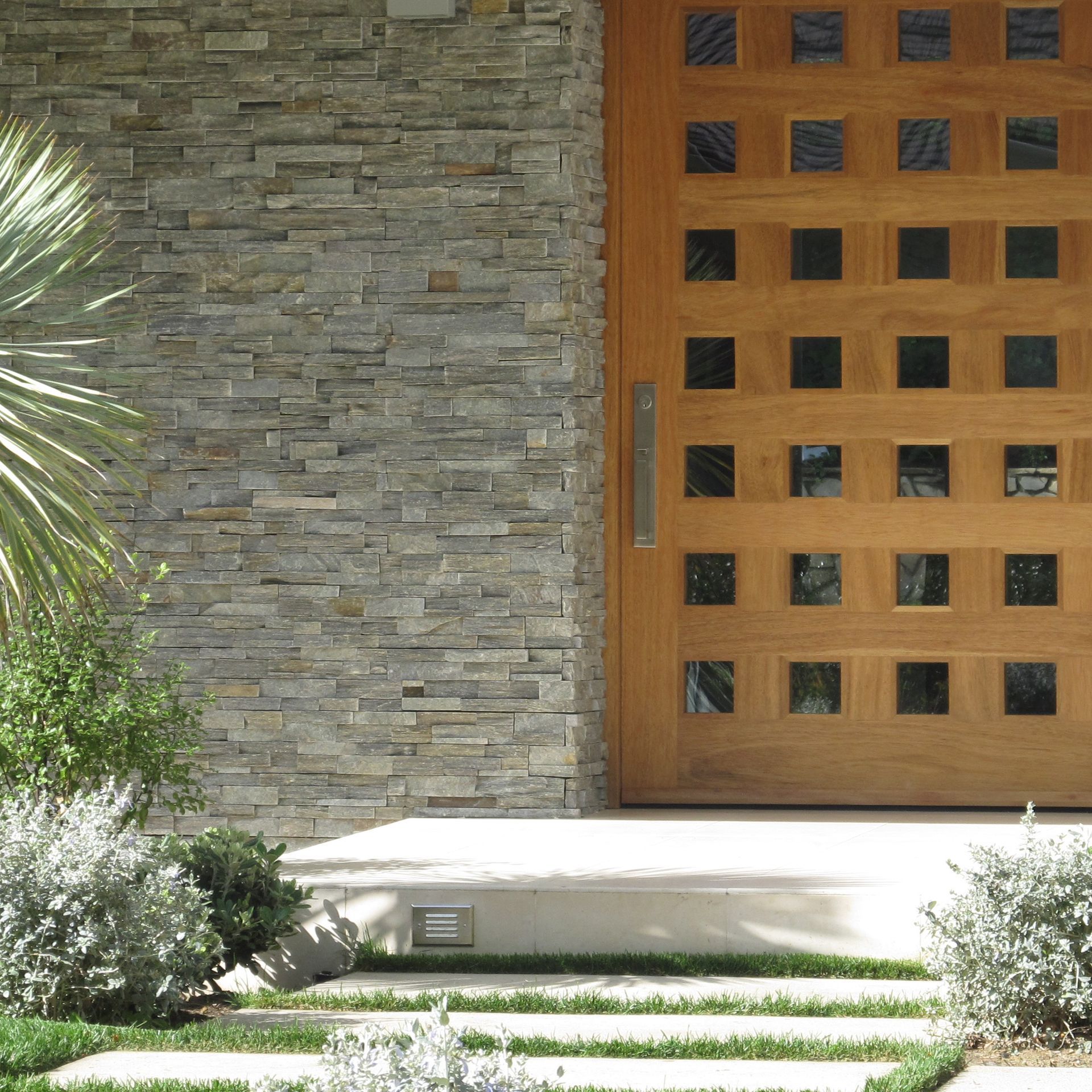 A wooden door in front of a stone wall.