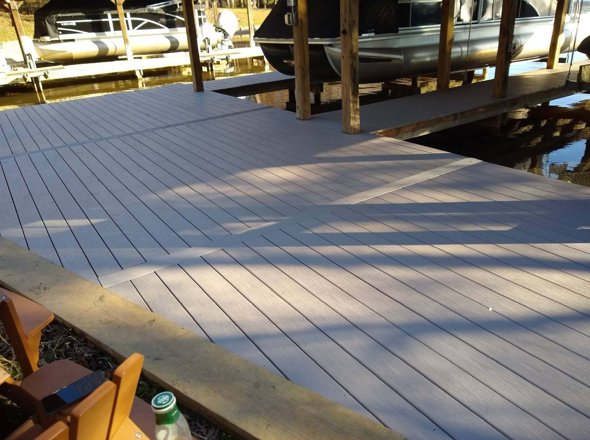 A boat is docked on a dock next to a bottle of water