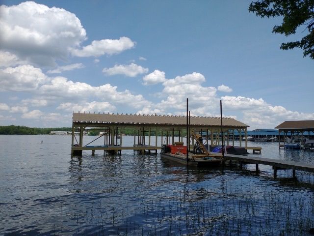 A boat is docked at a dock on a lake