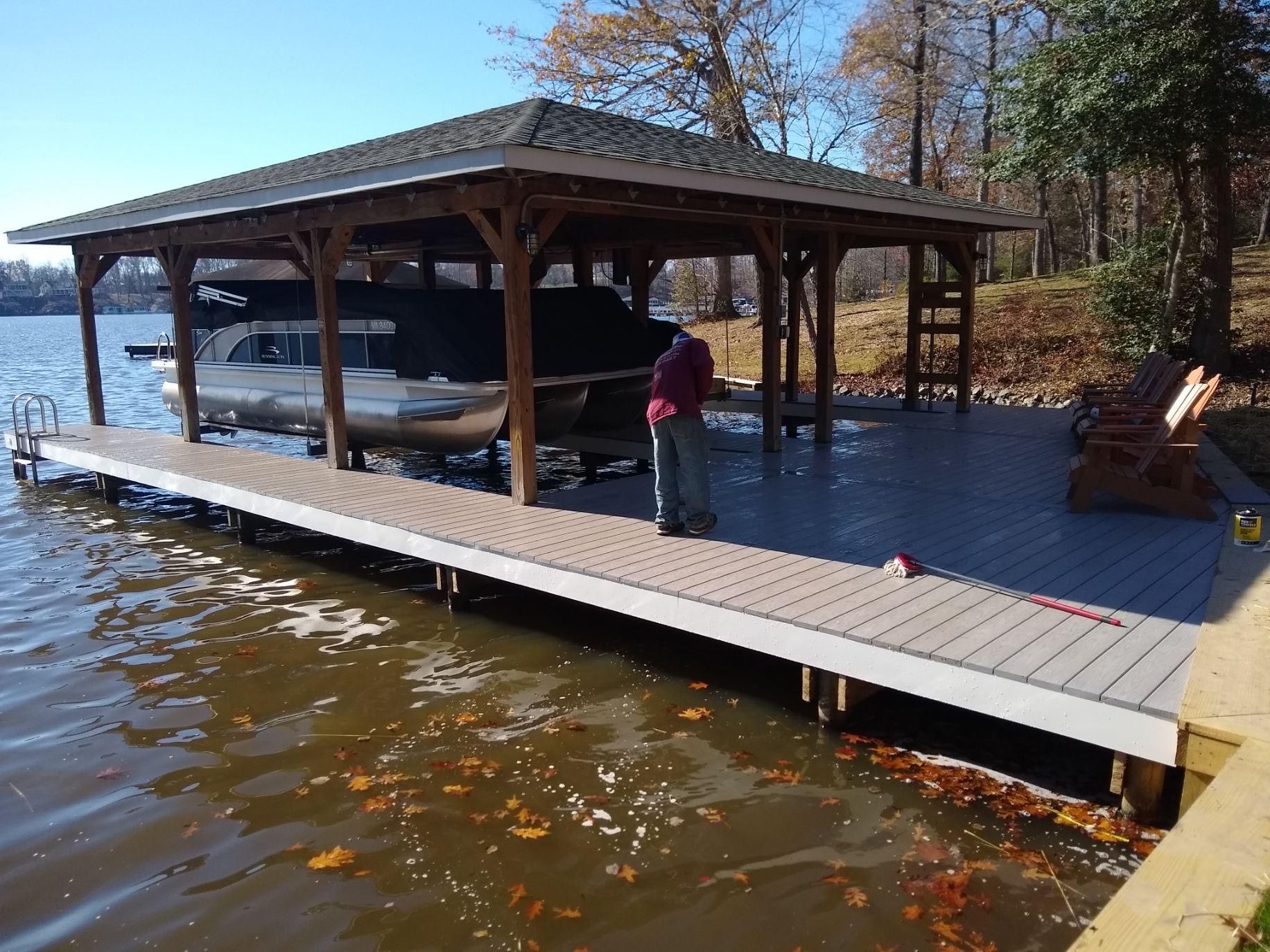 A man is standing on a dock next to a boat