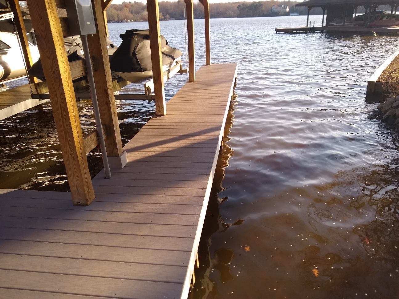 A boat is sitting on a dock next to a body of water.
